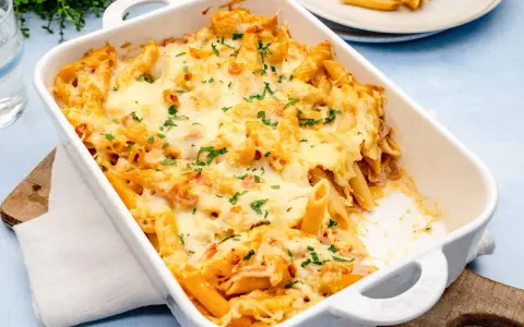 Herzhaftes Nudel Schinken Gratin mit geschmolzenem Käse und Petersilie, bereit zum Servieren.