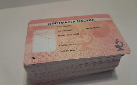 Stos nowych legitymacji szkolnych z miejscem na zdjęcie i danymi ucznia.