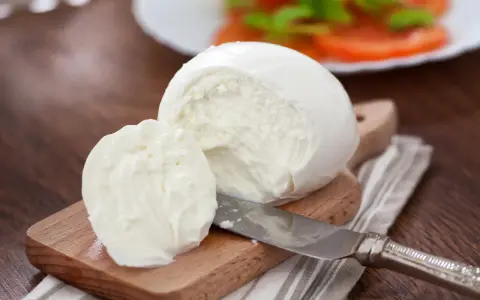 Świeża mozzarella na desce, gotowa do sałatki. Czy mozzarella jest wegetariańska? Tak, tradycyjnie tak!