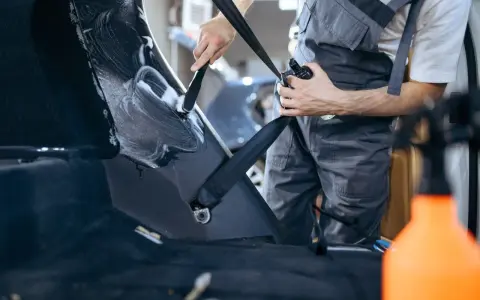 Ręczne polerowanie plastiku w bagażniku samochodu. Czystość i blask dzięki starannej pracy.