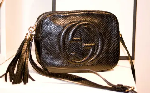 Czarna, pikowana torebka Gucci z wytłoczonym logo i frędzlami. Klasyczne, stylowe modele torebek Gucci.