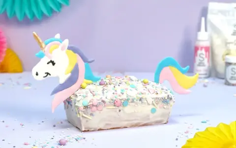 Ein magischer einhorn kuchen, verziert mit bunten Streuseln und einem süßen Einhorn-Topper, bereit für eine märchenhafte Feier.