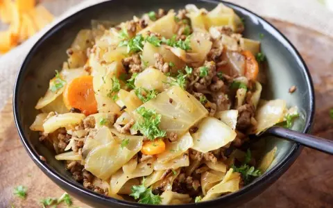 Herzhaftes Spitzkohlgericht mit Hackfleisch und Karotten, garniert mit frischer Petersilie. Ein deftiges Essen, das gut schmeckt.