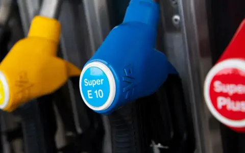 Zapfen für Super E10, einen Benzinmix mit Ethanol, und Super Plus an einer Tankstelle.