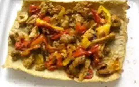Un wrap poulet poivron, garni de morceaux de poulet et de poivrons colorés, prêt à être dégusté.