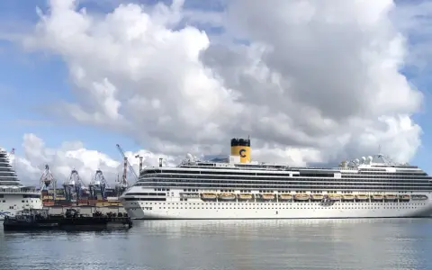 Grandi navi da crociera attraccate al terminal crociere La Spezia, con gru portuali sullo sfondo e un cielo nuvoloso.