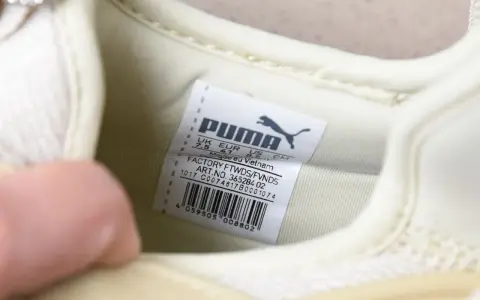 Oryginalna metka Puma na jasnej podeszwie buta, z informacjami o rozmiarze i pochodzeniu.