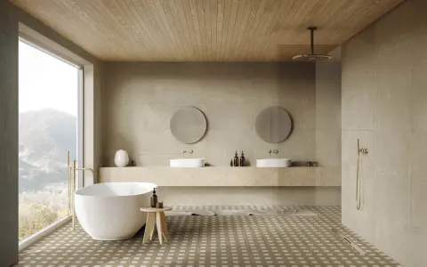 Elegante baño con bañera exenta, lavabos dobles y ducha. Las paredes y el suelo combinan baño color beige y madera, creando un ambiente sereno.