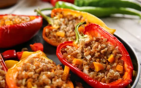 Peperoni ripieni senza carne, un piatto colorato e gustoso. Ripieno di riso e verdure, un'esplosione di sapori.
