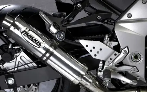 Błyszczący tłumik motocyklowy Hurric, element układu wydechowego, który może pomóc w uzyskaniu basowego brzmienia.