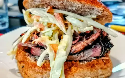 Sandwich con pulled pork, un classico della pulled pork ricetta, con pane integrale e insalata coleslaw cremosa.