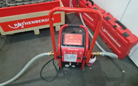 Equipo ROTHENBERGER para limpieza suelo radiante. Máquina roja con mangueras y maletines a juego.