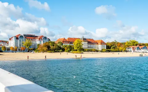 Piękna plaża z hotelami i spacerującymi ludźmi, idealne miejsce na weekendowy relaks nad morzem.