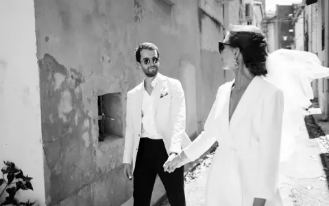 Un couple marié, main dans la main, traverse une ruelle. Ils pensent déjà aux démarches administratives après mariage au service public.