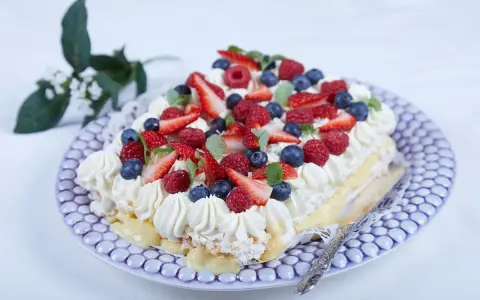 En vacker jordgubbstårta med grädde, bär och vaniljkräm. Perfekt för ett sommarfika, här är ett enkelt jordgubbstårta recept.