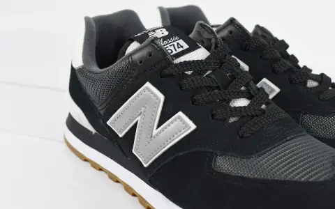 Czarne buty New Balance 574 z szarym logo "N" i gumową podeszwą. Czy Sizeer ma oryginalne buty? Tak, te wyglądają na autentyczne.
