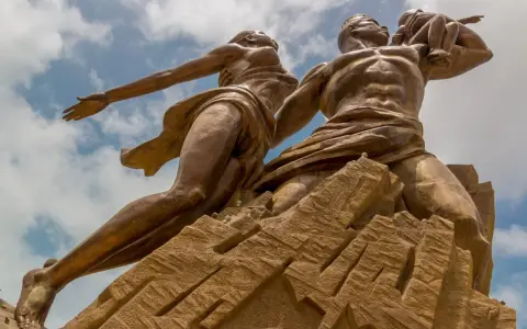 Pomnik Odrodzenia w Senegalu, symbolizujący dumę i przyszłość. Monumentalna rzeźba na tle błękitnego nieba.