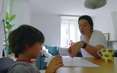 Mama tłumaczy synowi, co to są zgłoski, podczas wspólnej nauki.
