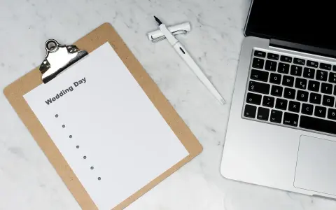 Planowanie harmonogramu zamawiania zaproszeń ślubnych, uwzględniając czas druku, to klucz do sukcesu. Na zdjęciu notatnik z listą zadań i laptop.