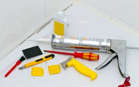 Attrezzi per la rimozione olio di silicone e sigillatura: pistola per silicone, taglierino, spatole, pennello e solvente.