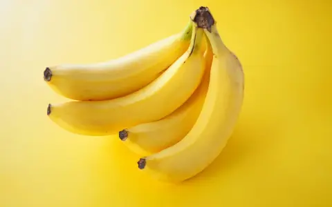 Pęczek żółtych bananów na jaskrawożółtym tle. Idealna przekąska, która dostarczy energii i nie obciąży zbytnio kalorycznie.