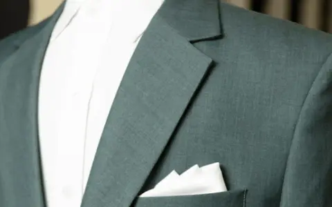 A close-up of a teal suit jacket shows the lapel and a crisp white pocket square.