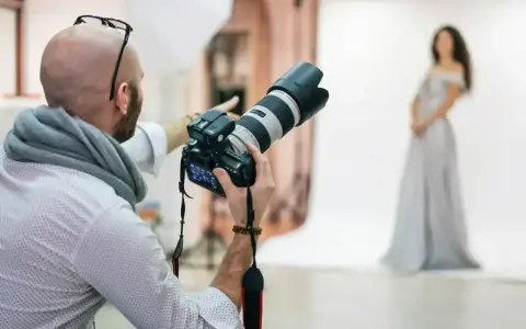Fotograf z aparatem przygotowuje sesję. Zastanawiasz się, ile kosztuje fotograf na 18. urodziny?