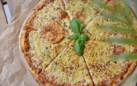 Pyszna pizza z serem i bazylią, idealne dodatki do pizzy.