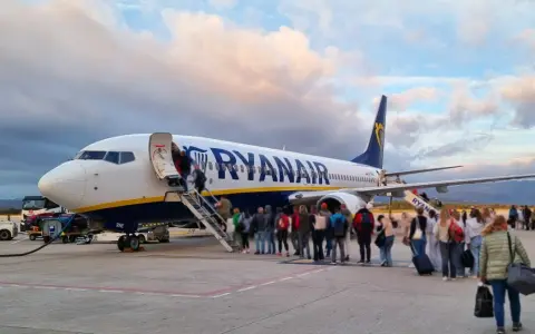 Samolot Ryanair z pasażerami wchodzącymi po schodach na pokład.