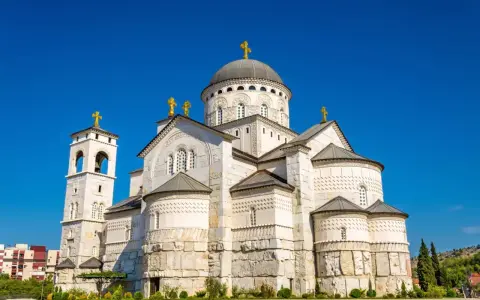 Sobór Zmartwychwstania Chrystusa, imponująca budowla w stolicy Czarnogóry, Podgoricy, z dominującą kopułą i złotymi krzyżami.