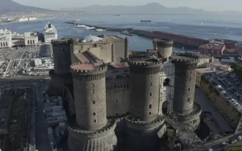 Maschio Angioino con la Cappella Palatina, imponente castello medievale a Napoli, affacciato sul mare con il Vesuvio sullo sfondo.