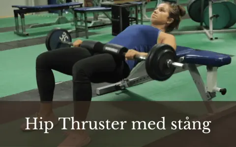 Kvinna utför hip thrust med stång på en bänk i ett gym.
