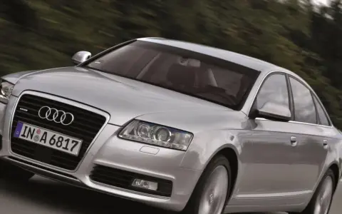 Silberner Audi A6 Limousine 2005 fährt auf einer Landstraße.