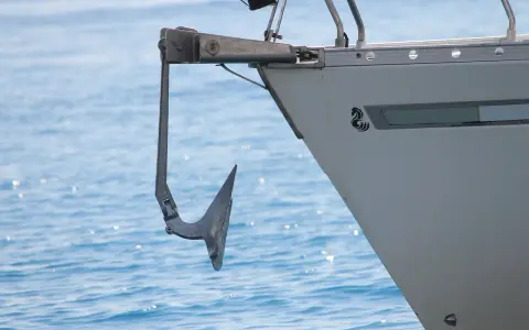Ancre de bateau suspendue à la proue, prête pour l'action. Une image qui illustre comment remonter une ancre de bateau.