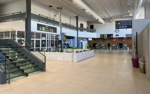 Inside an airport terminal, signs point to boarding gates 1-6. This is likely the closest airport to San Sebastian.