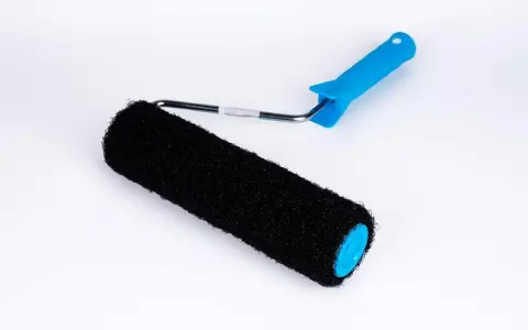 En svart roller med blått handtag, perfekt för att applicera rullspackel jämnt på väggar.