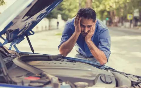 Hombre frustrado mira el motor de su coche. El motor gira pero no arranca diesel.