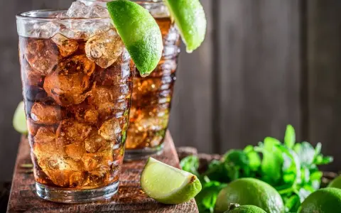 Dwa orzeźwiające drinki z rumem i lodem, ozdobione limonką. Idealne na upalne dni, zastanawiasz się, jaki rum do herbaty będzie najlepszy?