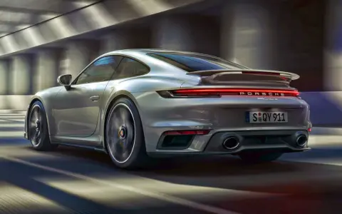 Srebrne Porsche 911 Turbo S pędzi przez tunel. Zastanawiasz się, ile kosztuje Porsche 911?