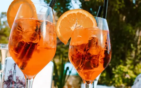 Dwa orzeźwiające drinki z pomarańczą i lodem, idealne na włoskie aperitivo.
