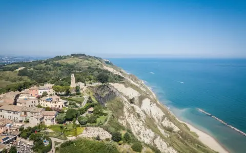 Panoramica aerea di Gabicce Mare, con case arroccate su una collina a picco sul mare Adriatico.