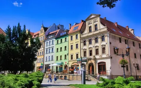 Kolorowe kamienice na rynku w Złotoryi, zachęcające do odkrywania urokliwych zakątków i atrakcji miasta.