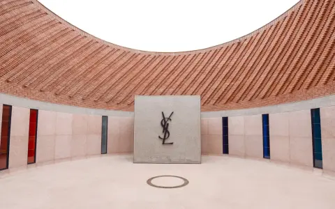 Logo Yves Saint Laurent nel **museo Yves Saint Laurent Marrakech**, con pareti in mattoni e vetrate colorate.