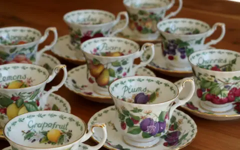 Service à thé en porcelaine anglaise, orné de fruits variés : citrons, prunes, raisins, cerises, poires, pamplemousses.