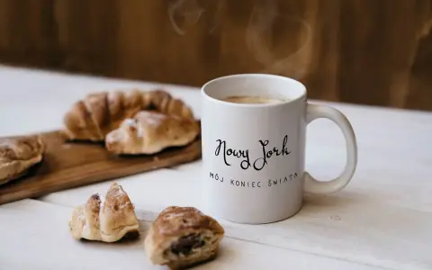 Kawa i croissanty, idealne na śniadanie. Kubek z napisem "Nowy Jork, mój koniec świata" to świetny pomysł, co kupić w USA do Polski.