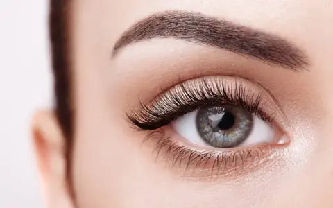 Ojo de mujer con pestañas largas y cejas definidas. Descubre cómo hacer crecer las pestañas para una mirada impactante.
