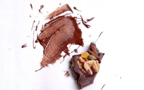 Manchas de chocolate derretido y trozo de chocolate con frutos secos. ¿Cómo quitar manchas que no sabes de qué son?