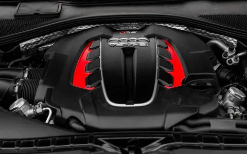 Silnik V8 TFSI, co to znaczy? Potężna jednostka napędowa z czerwonymi akcentami, symbol mocy i inżynierii.