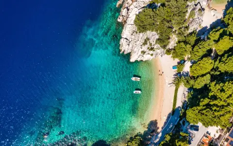 Rajska plaża z krystalicznie czystą wodą i łodziami. Idealne miejsce, by zastanowić się, gdzie do Chorwacji na wakacje.