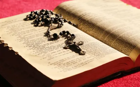 Różaniec i otwarta Biblia, symbol codzienna modlitwa do niepokalanej.